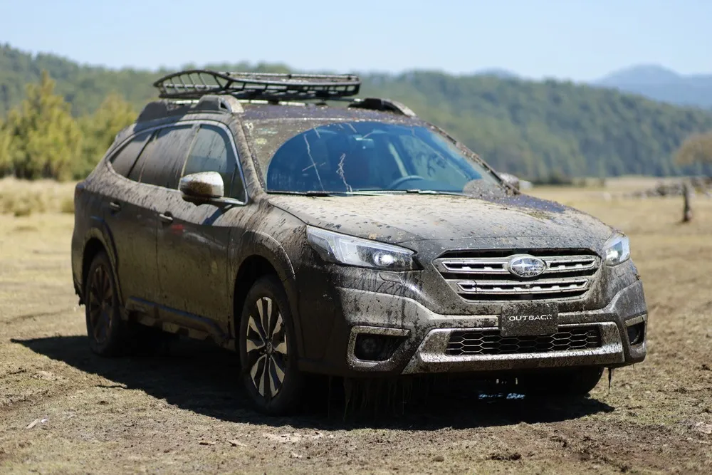 Subaru Outback with a roof rack in the mountains