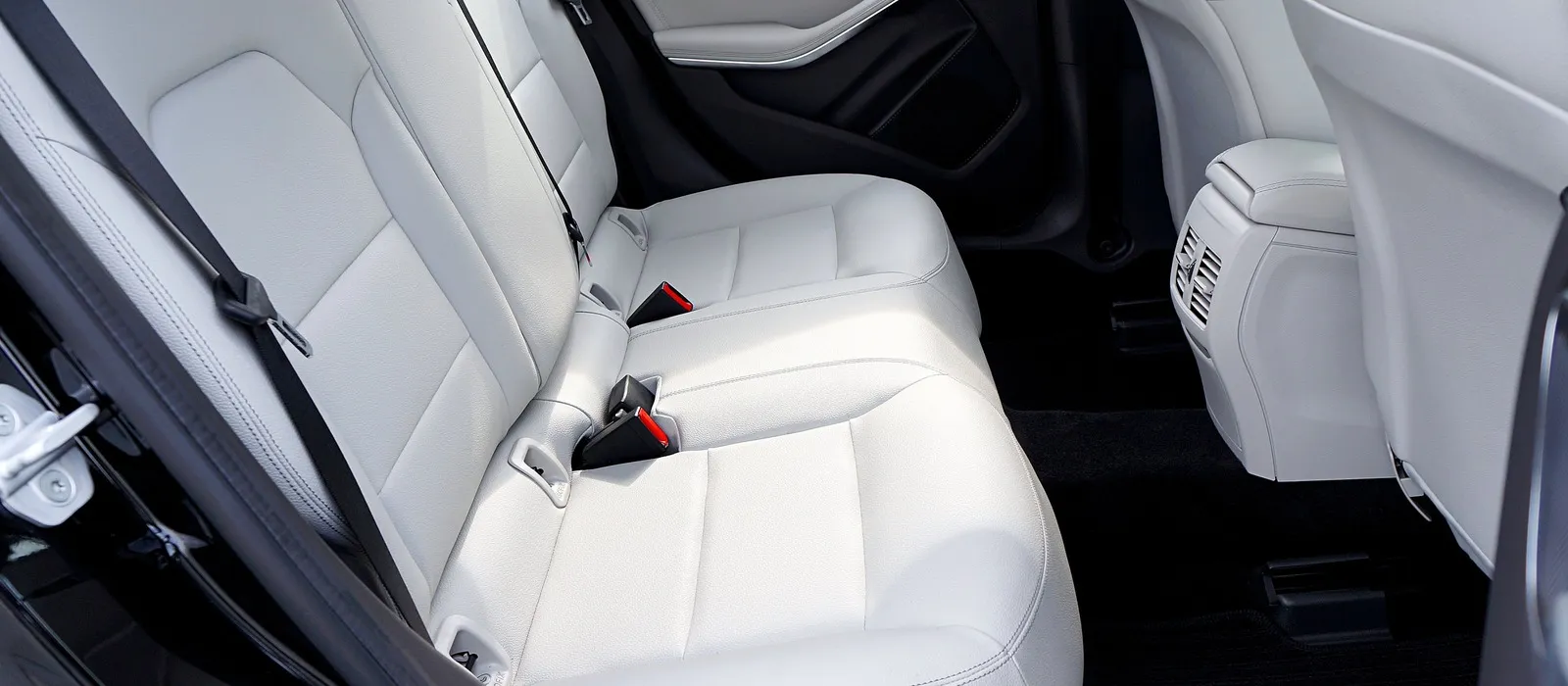 Rear seat belts in a light leather car interior